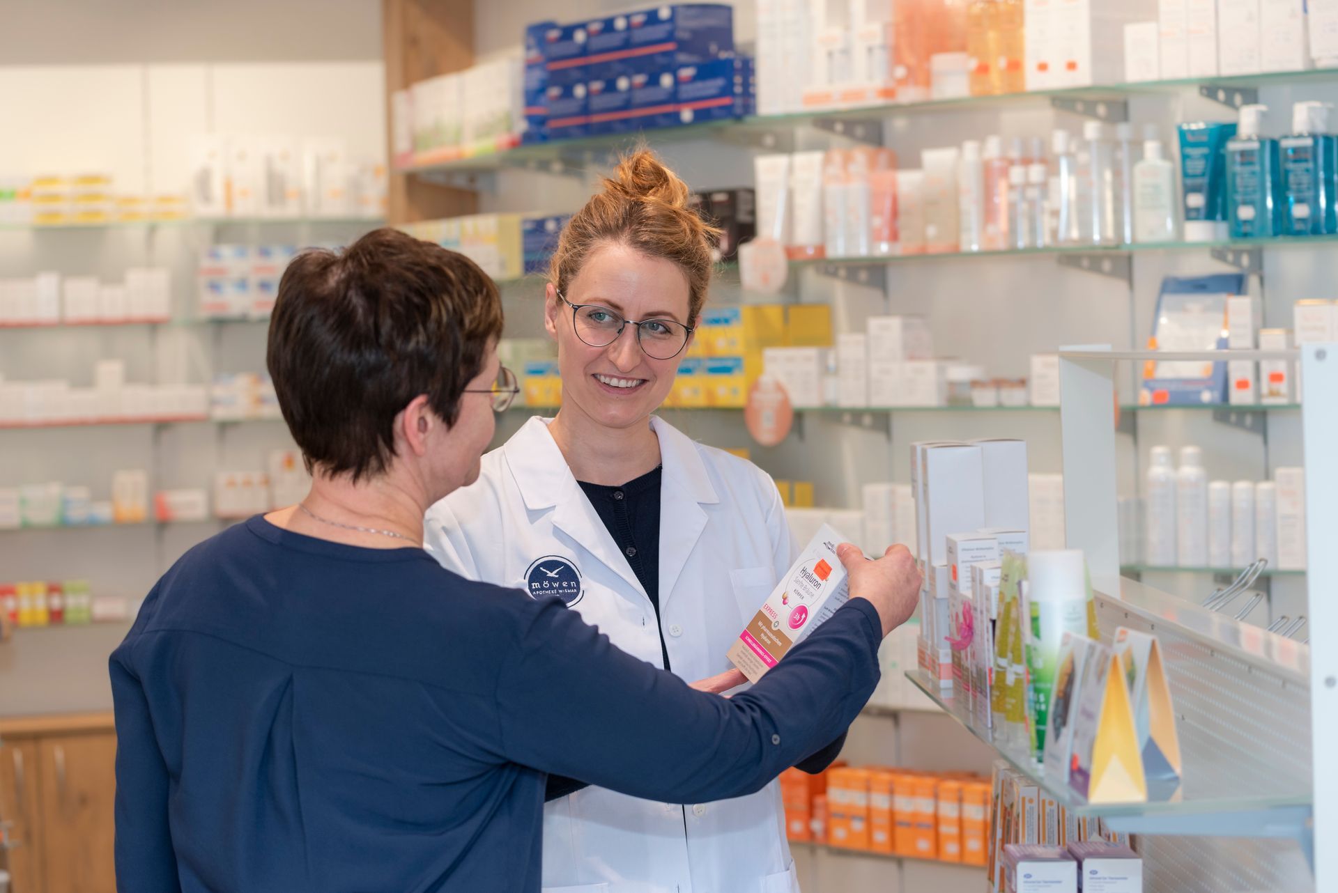 Eine Apothekerin spricht mit einer Frau in einer Apotheke.