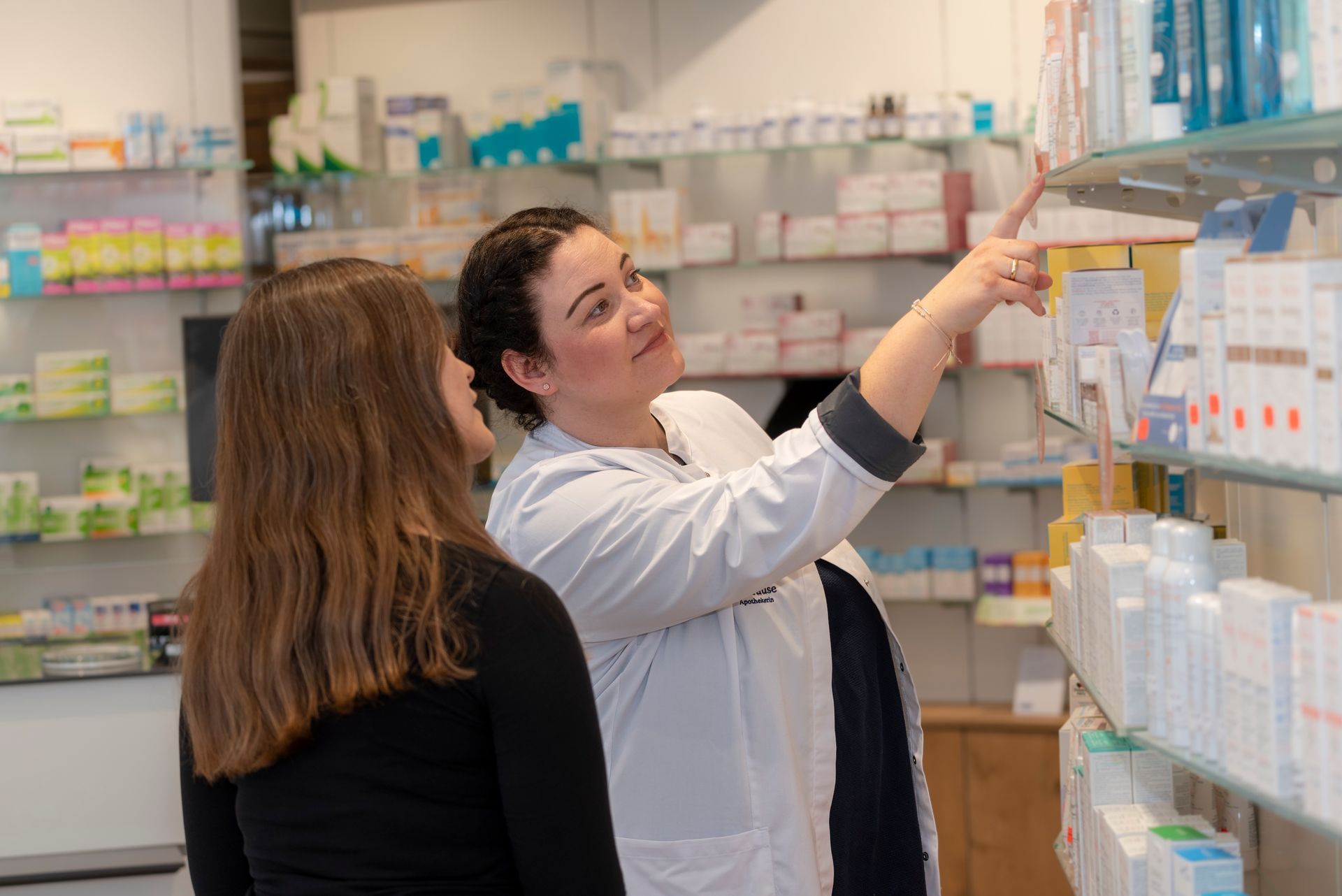 Eine Apothekerin spricht mit einer Frau in einer Apotheke.
