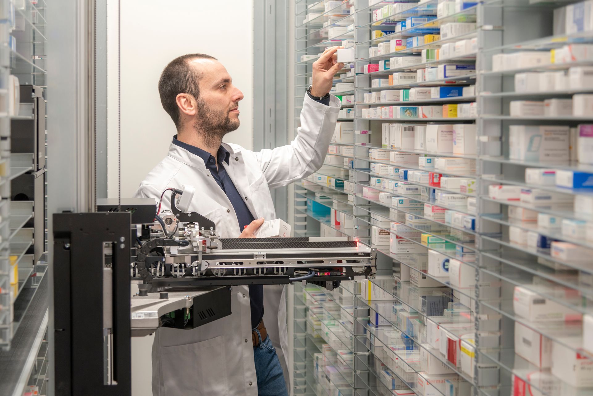 Ein Mann im Laborkittel arbeitet in einer Apotheke.