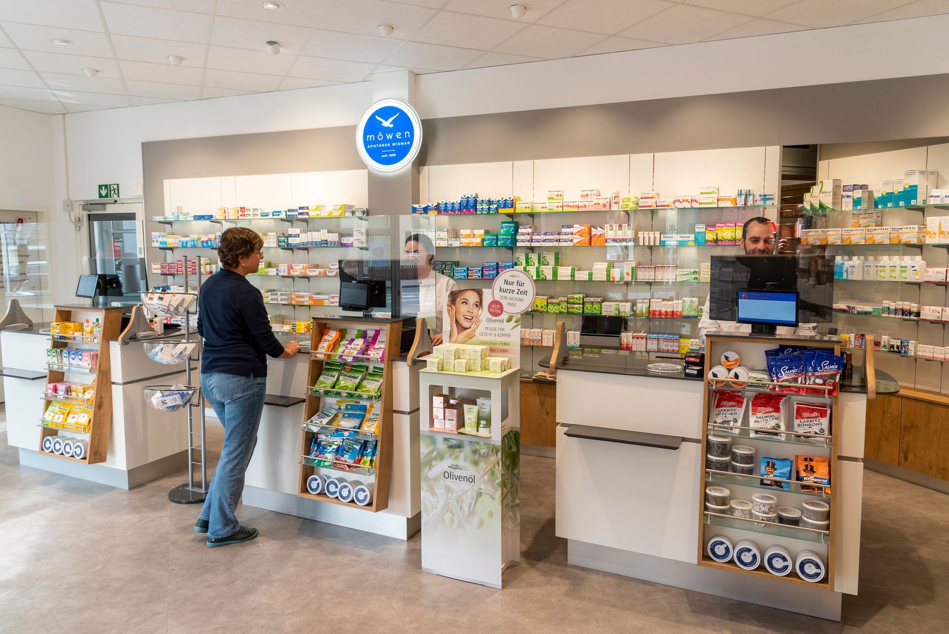 Eine Frau steht an einem Tresen in einer Apotheke.