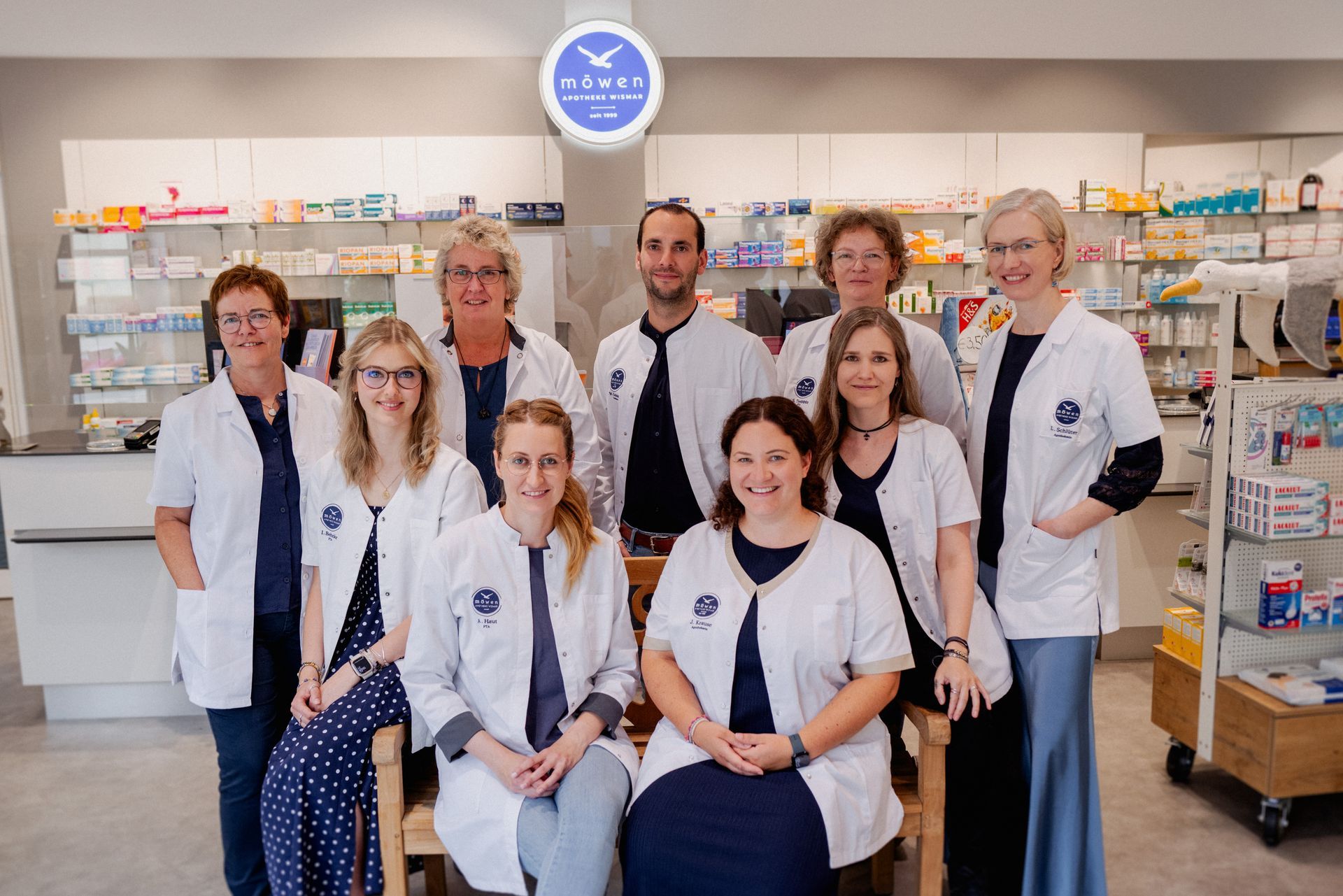 Eine Gruppe von Menschen posiert in einer Apotheke für ein Foto.