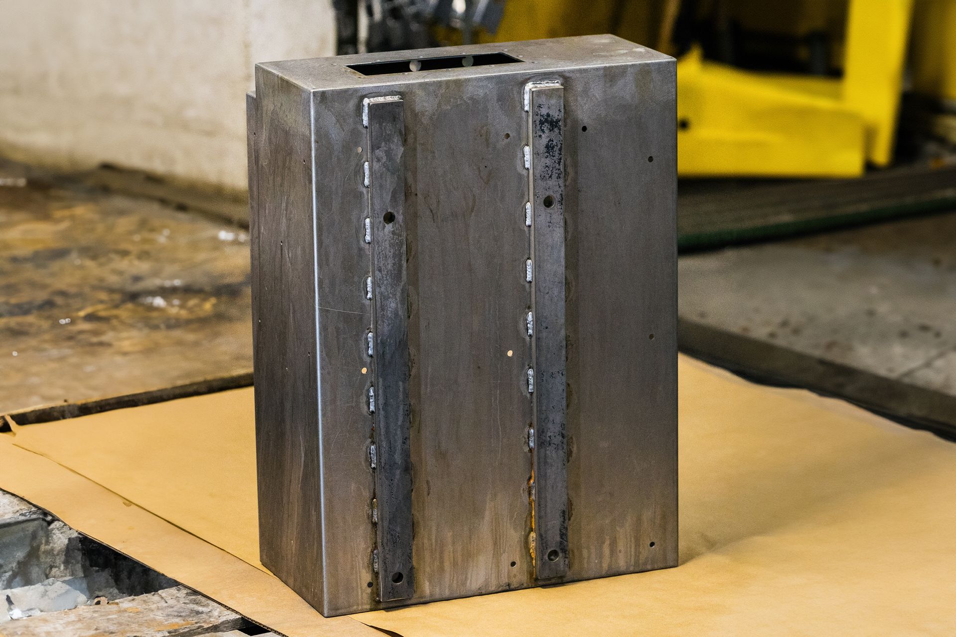 A piece of metal is sitting on top of a piece of cardboard.
