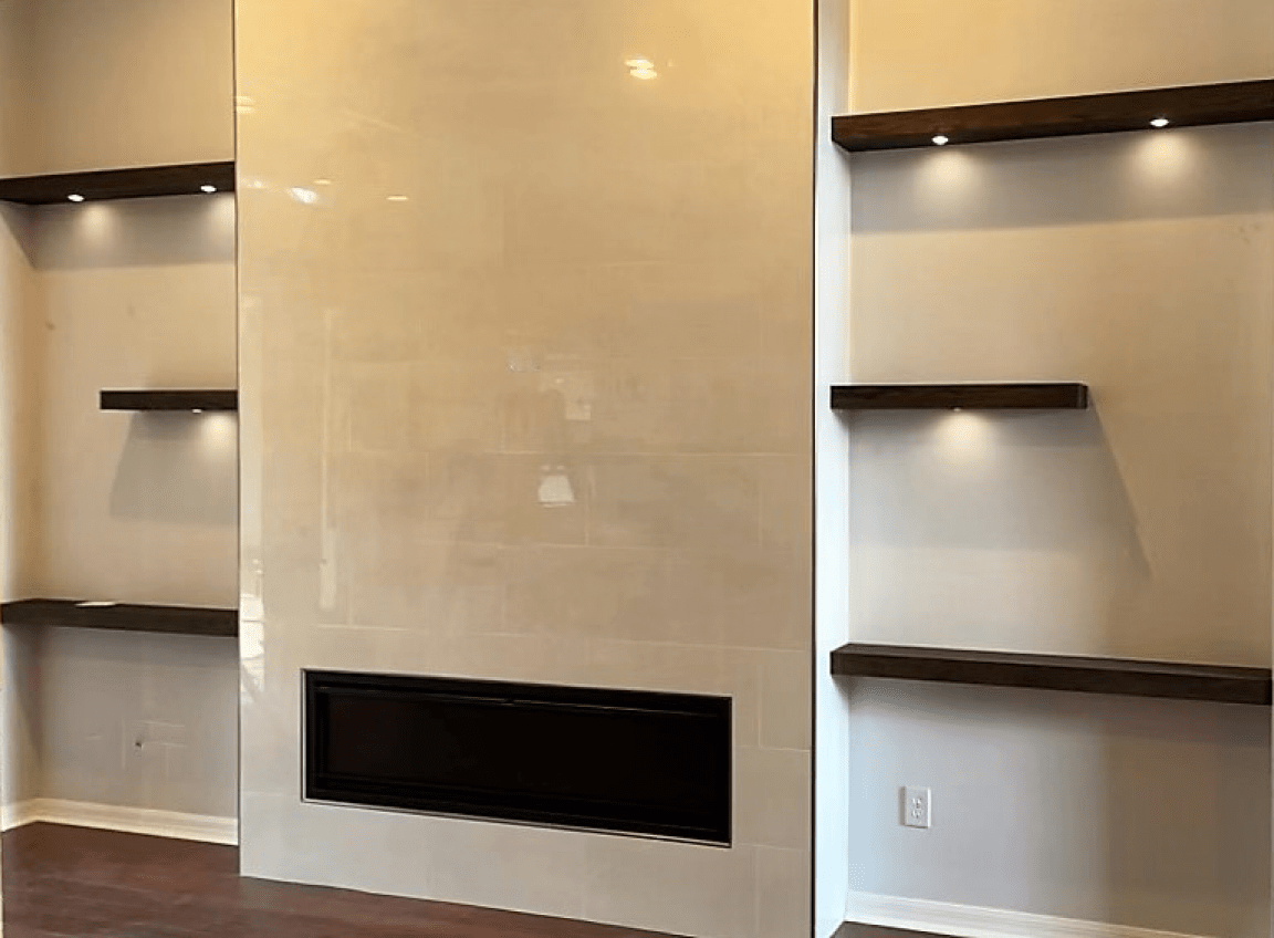 Empty living room wall with built-in dark wood shelves and a central fireplace opening
