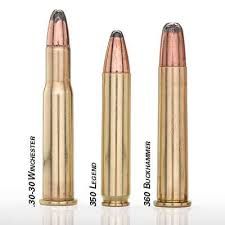 Three different types of bullets are lined up next to each other on a white surface.