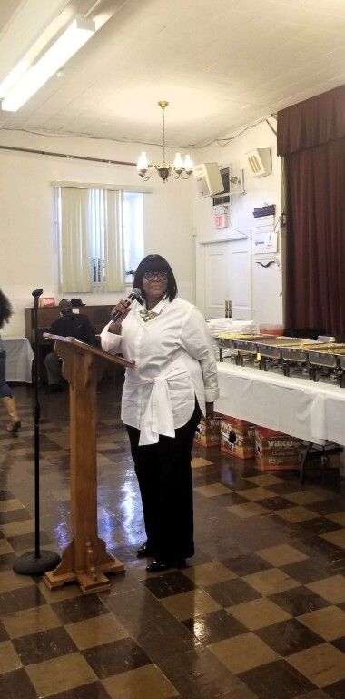 A woman is standing at a podium speaking into a microphone.