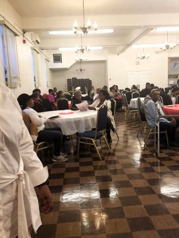 A group of people are sitting at tables in a large room