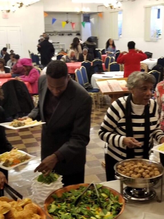 A group of people are gathered at a buffet table