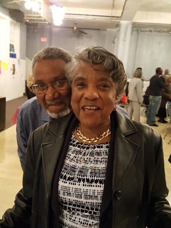 A man and a woman are posing for a picture in a room