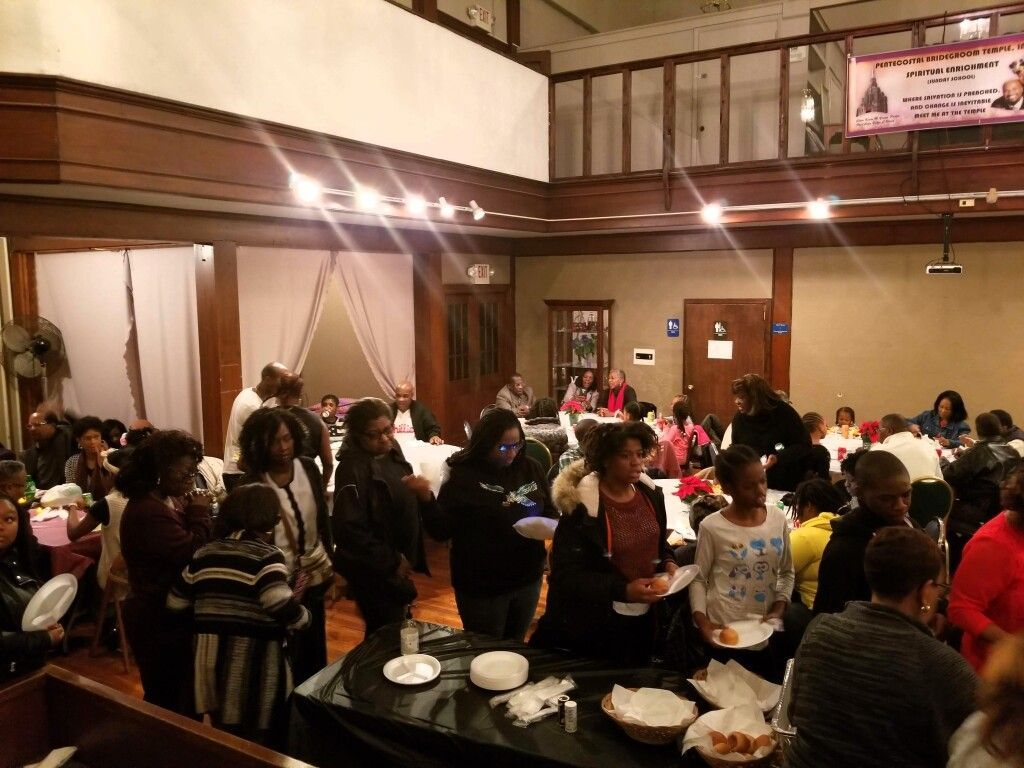A large group of people are standing around tables in a room.
