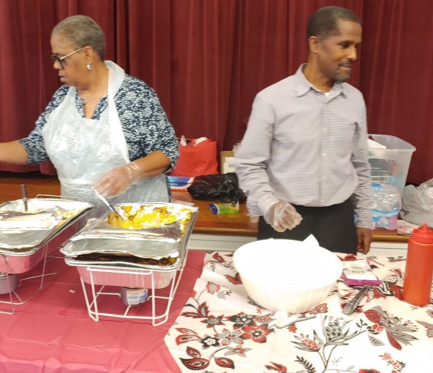 A man and a woman are preparing food on a table
