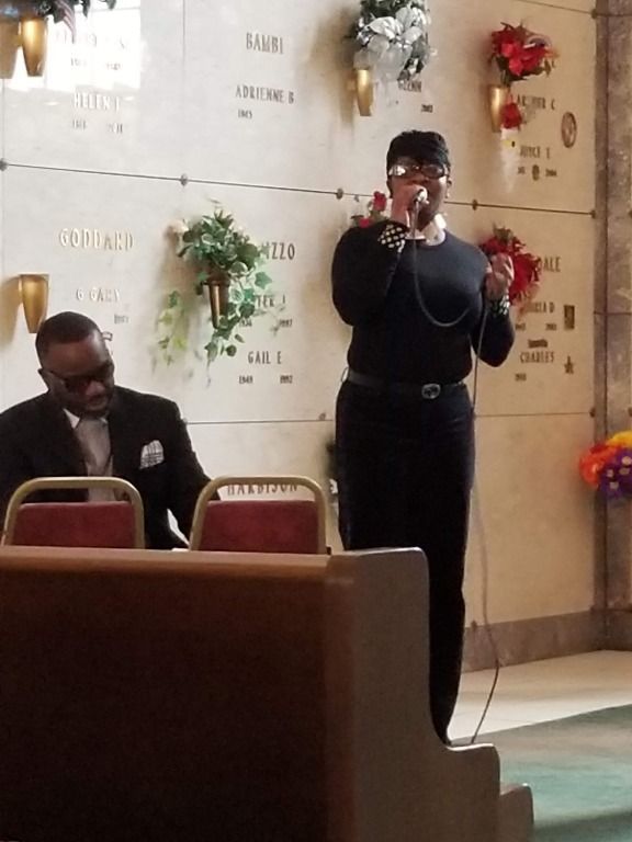 A woman singing into a microphone in a cemetery