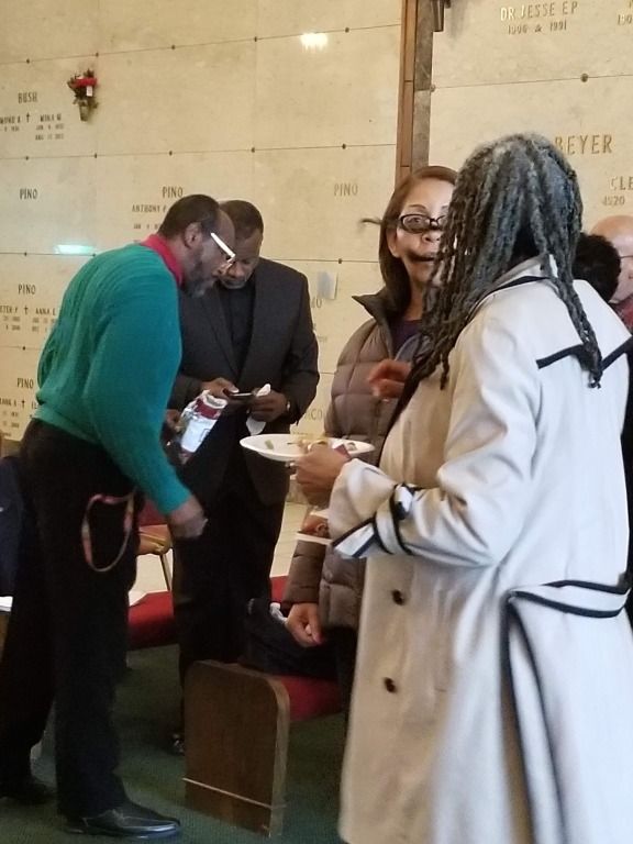 A group of people standing in front of a wall that has the word jesus on it