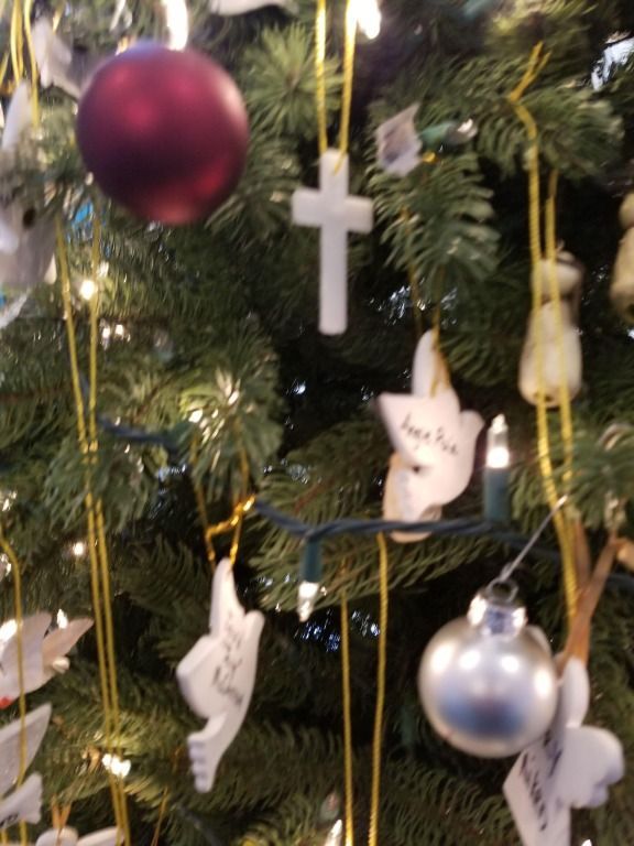 A christmas tree with a cross hanging from it