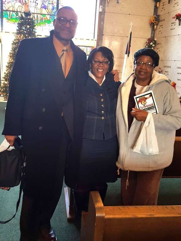 A man and two women pose for a picture in a church