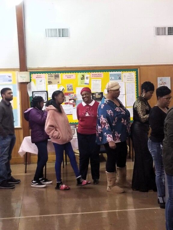 A group of people standing in front of a yellow board