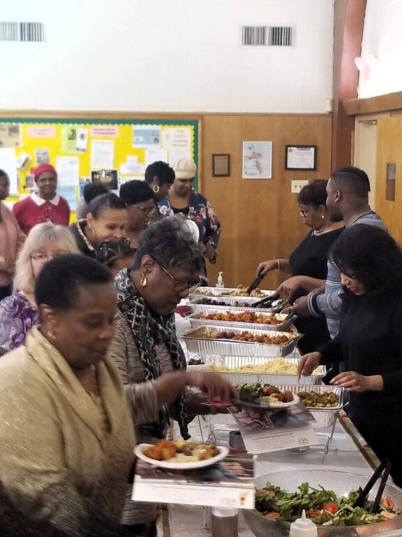 A group of people are gathered at a buffet table