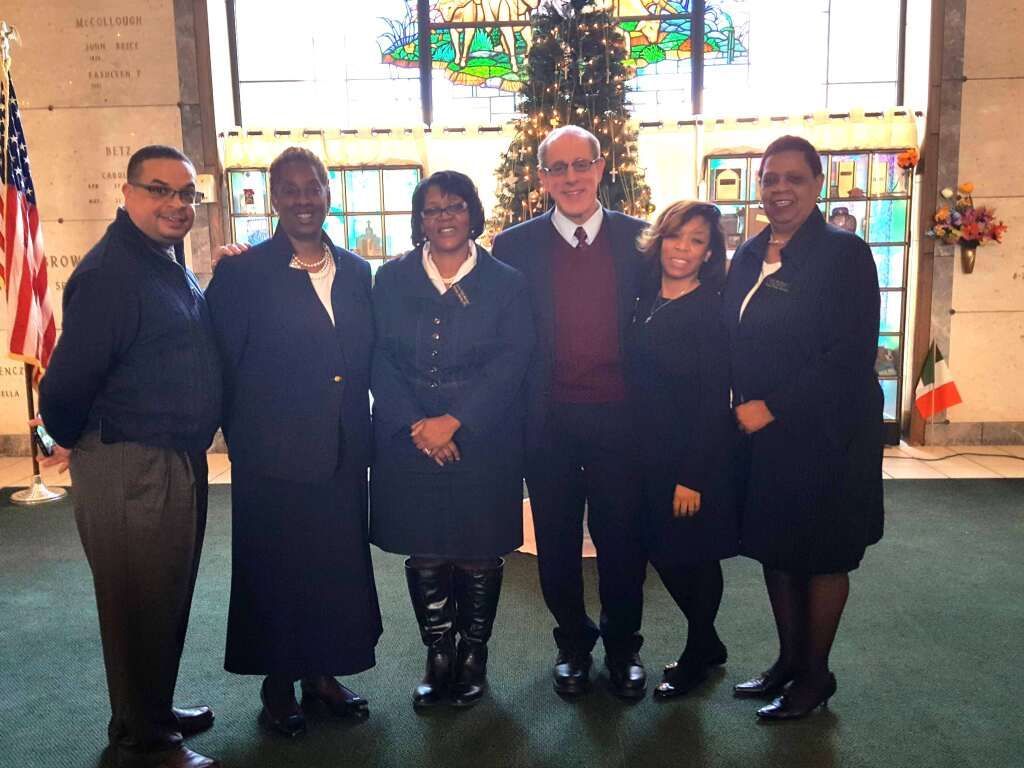 A group of people standing in front of a christmas tree
