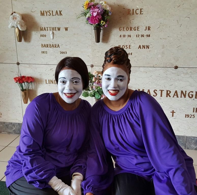 Two women are posing for a picture in front of a wall that says rice