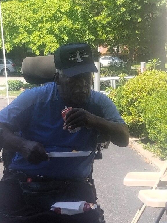 A man in a wheelchair is eating a can of soda.
