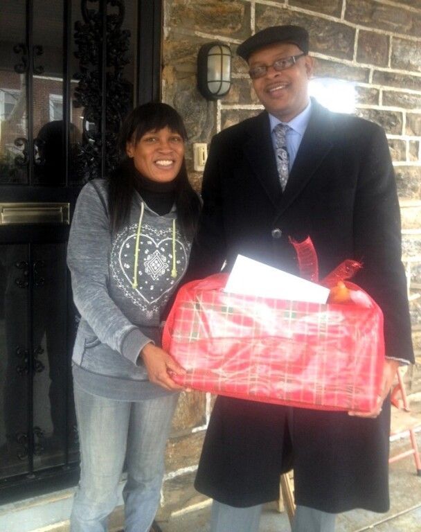 A man and a woman standing next to each other holding a red bag