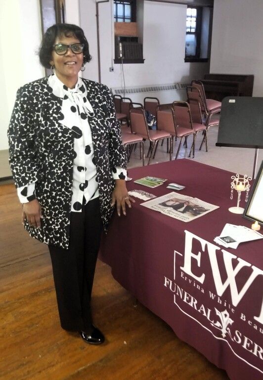 A woman is standing in front of a table that says ewt