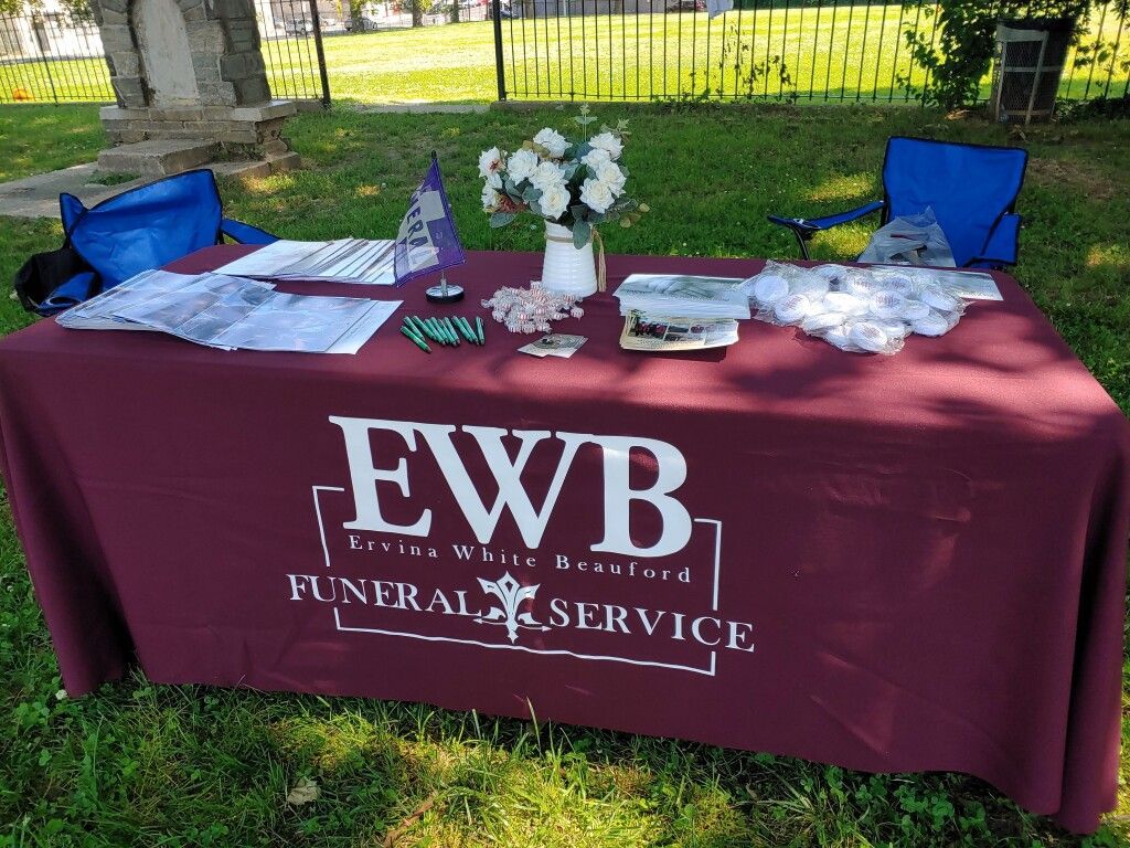 A table with a red table cloth that says ewb funeral service