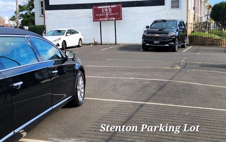 A black car is parked in a parking lot next to a white car.