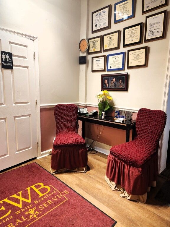 A waiting room with two chairs and a rug that says ewb