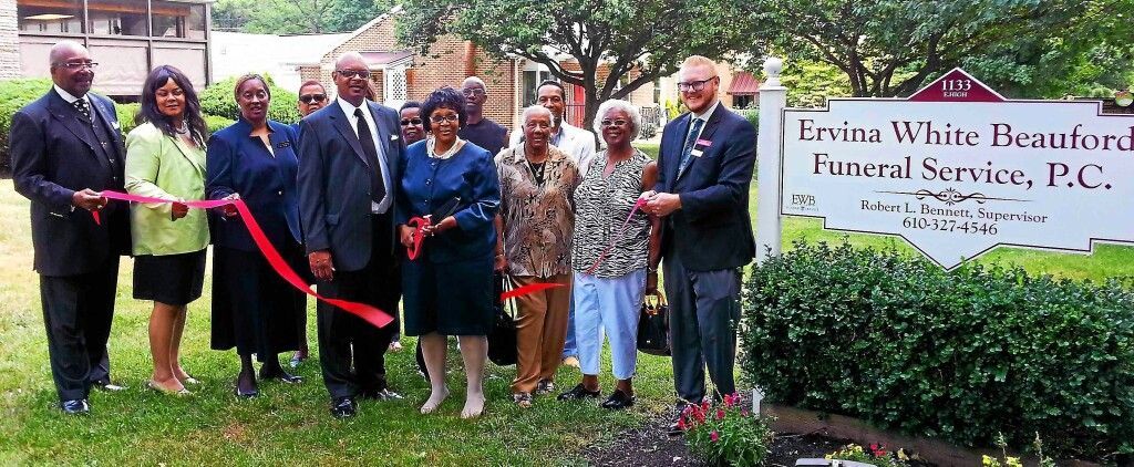 A group of people standing in front of a sign that says emma white headfirst funeral service p.c.