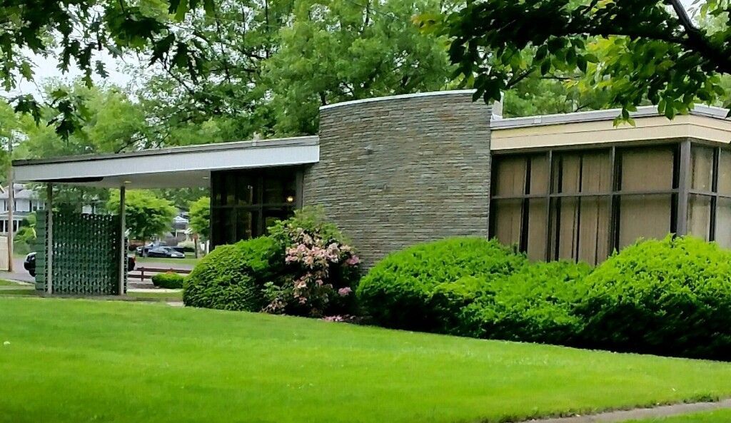 A large building with a lush green lawn in front of it