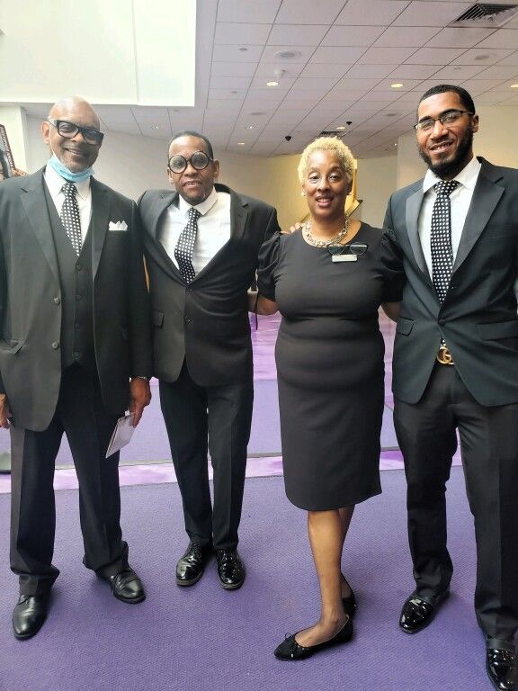 A group of people in suits and ties are posing for a picture.