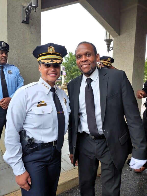 A police officer and a man in a suit pose for a picture