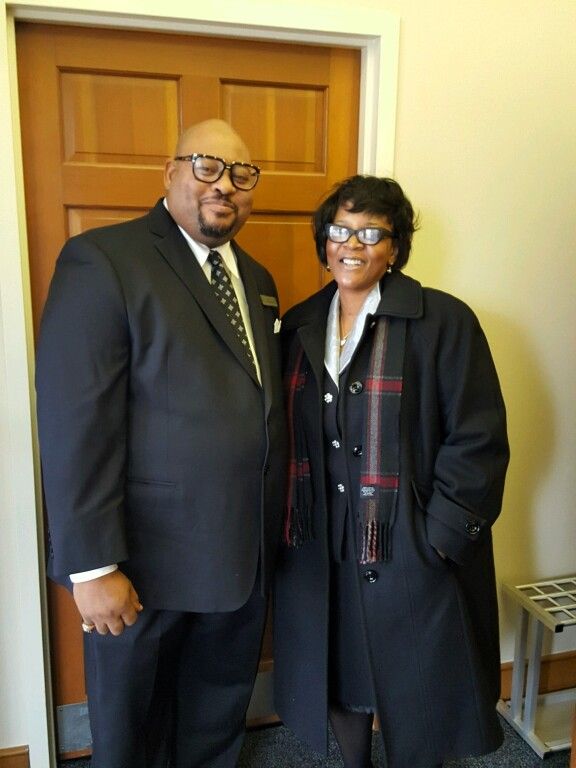 A man and woman are posing for a picture in front of a door