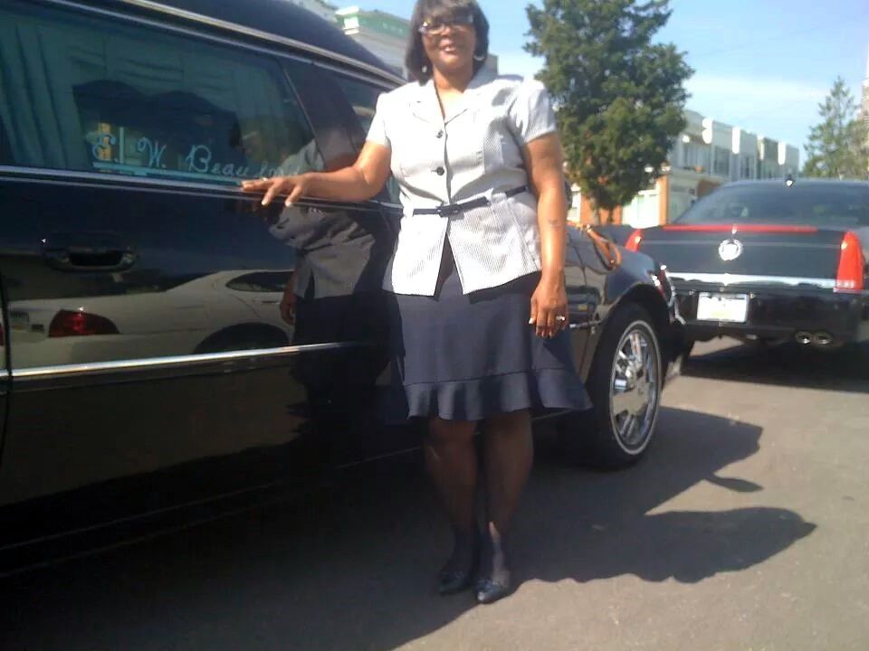 A woman is standing in front of a black limousine that says i love you