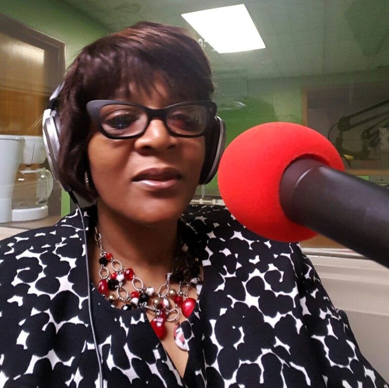 A woman wearing headphones and a red microphone