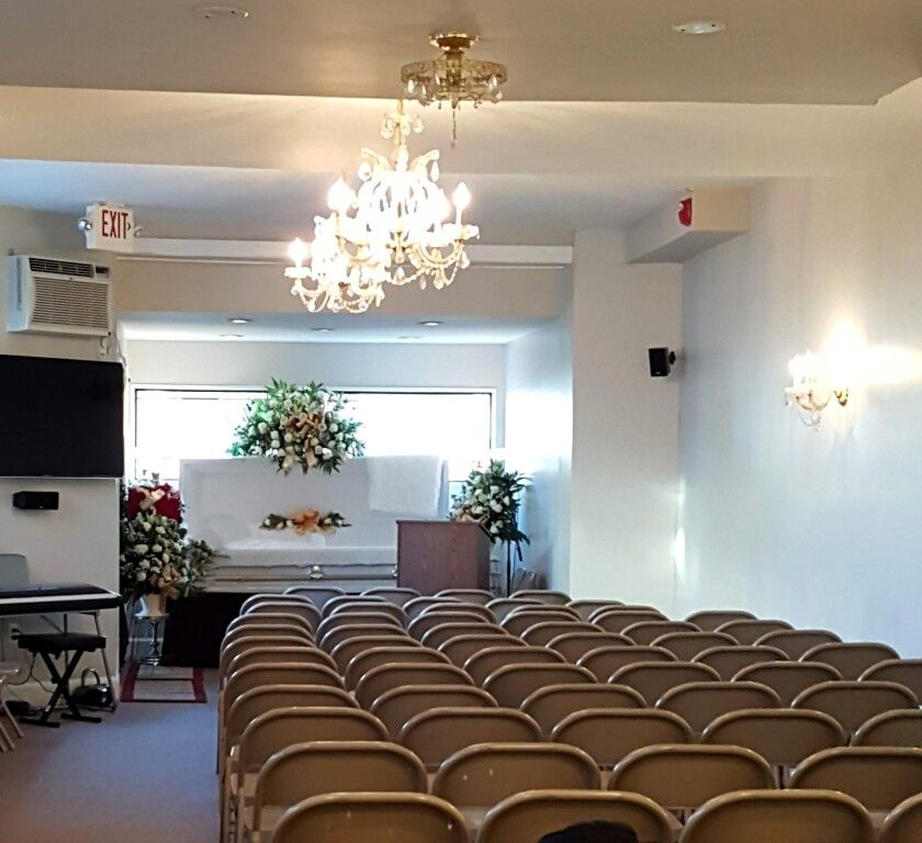 An empty auditorium with rows of chairs and an exit sign