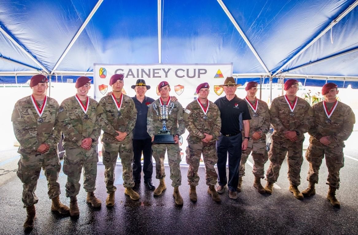 A group of soldiers are posing for a picture under a tent.