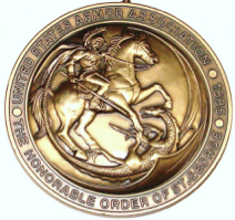 A bronze medal with a man on a horse fighting a dragon.