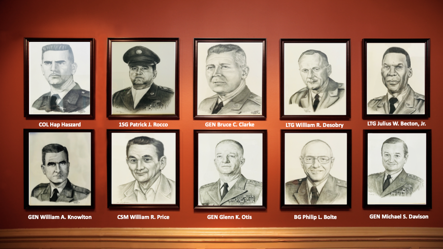 A group of portraits of men are hanging on a wall.