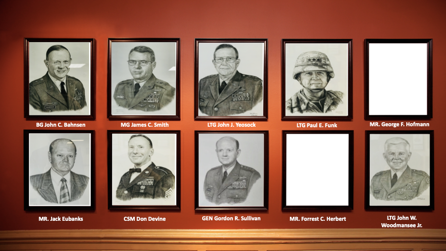 A row of black and white portraits of military men on a red wall.