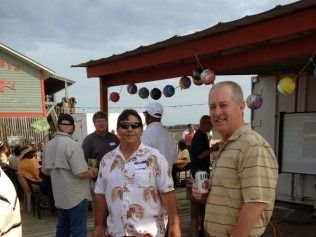 Group of people at an outdoor gathering near a building with balloons.