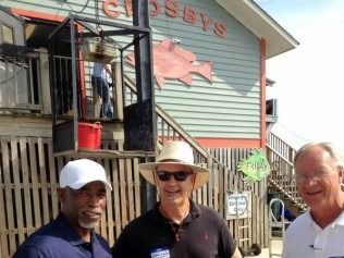 Three men standing outside a seafood restaurant, 