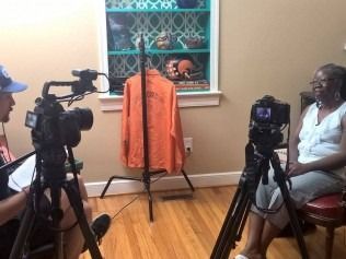 Woman being interviewed; two cameras on tripods.