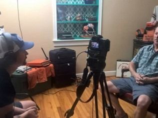 Two people in a room, filming an interview. 