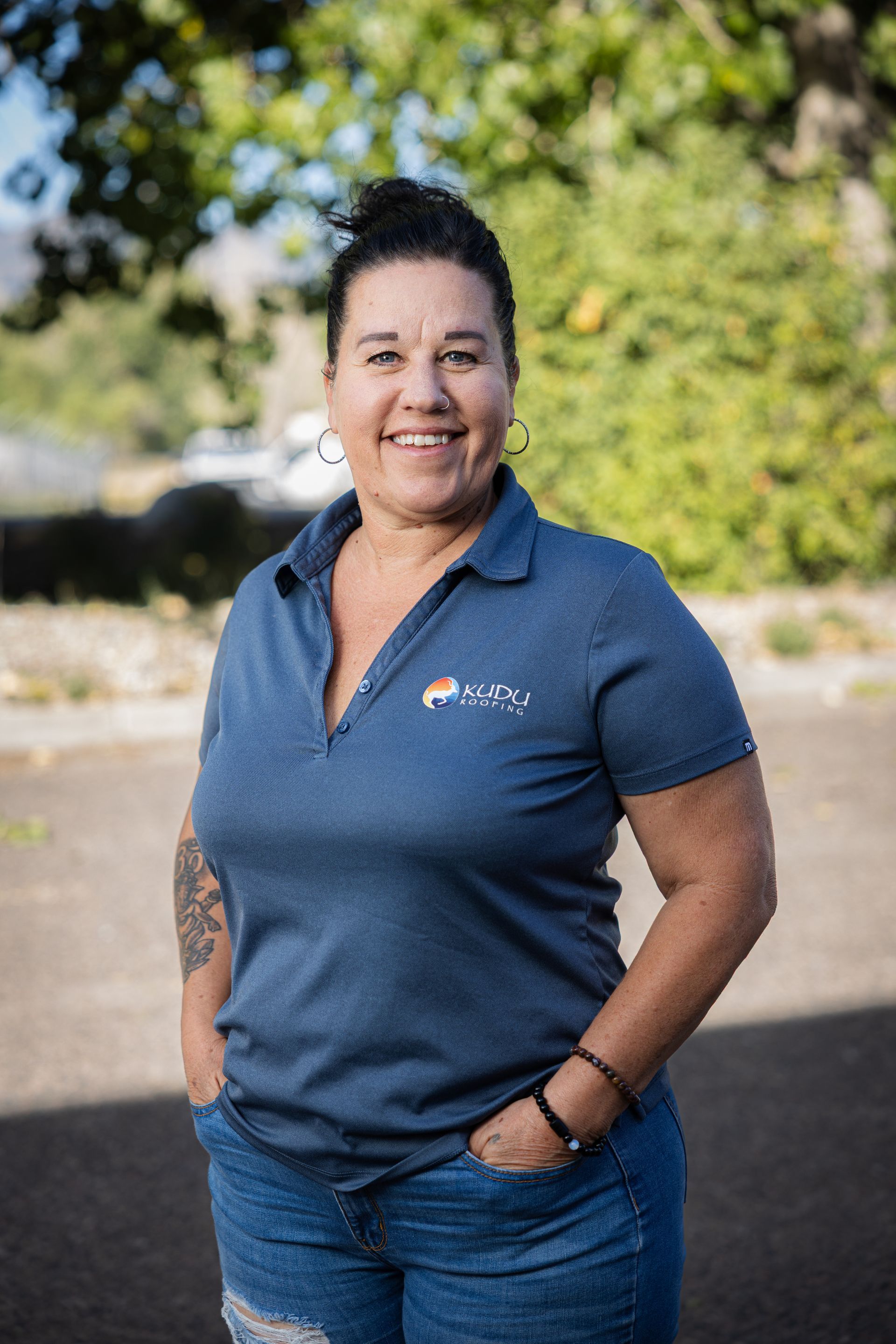 A woman in a blue shirt is smiling for the camera.