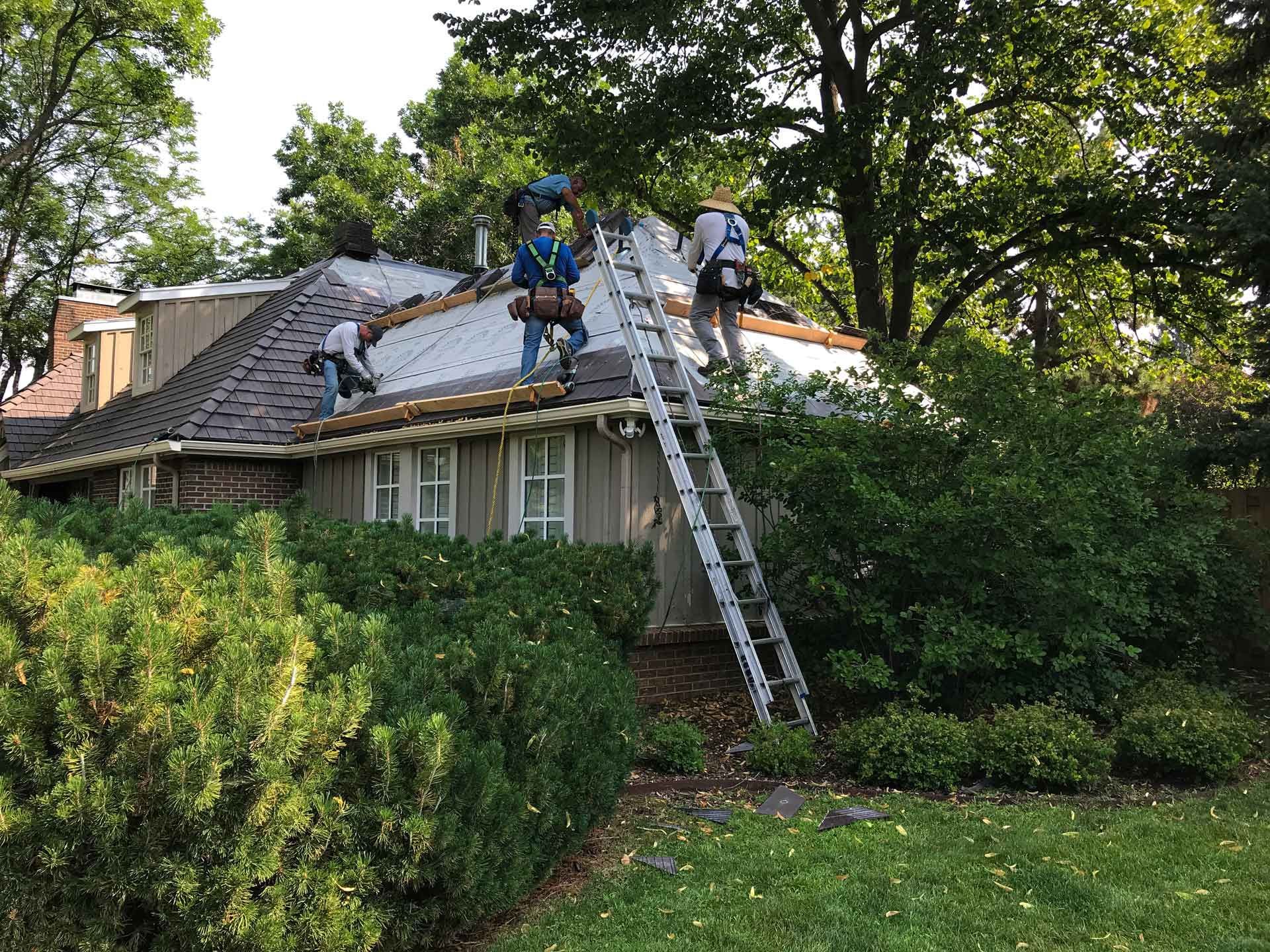 A group of men are working on the roof of a house.