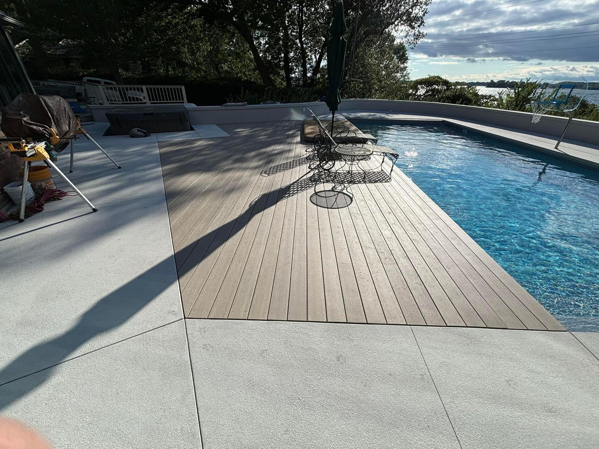 A large swimming pool with a wooden deck in front of it