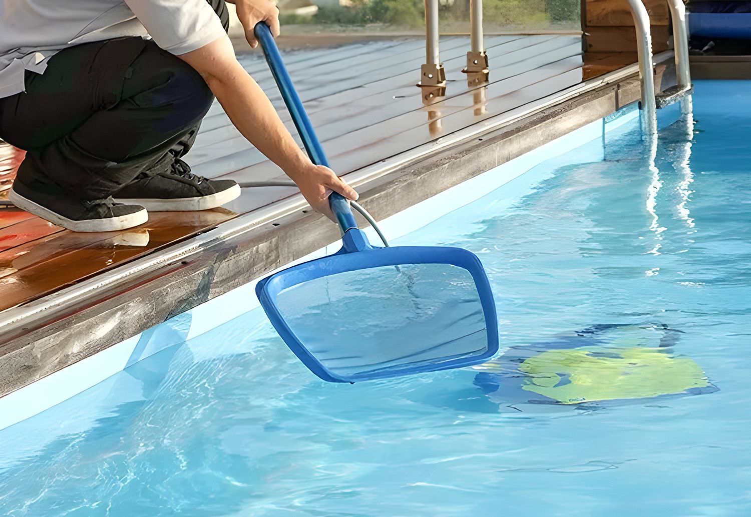 A Handheld Pool Net Removing Debris From A Swimming Pool