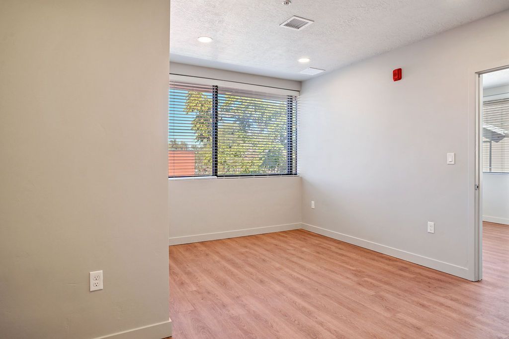 An empty room with hardwood floors and a window.