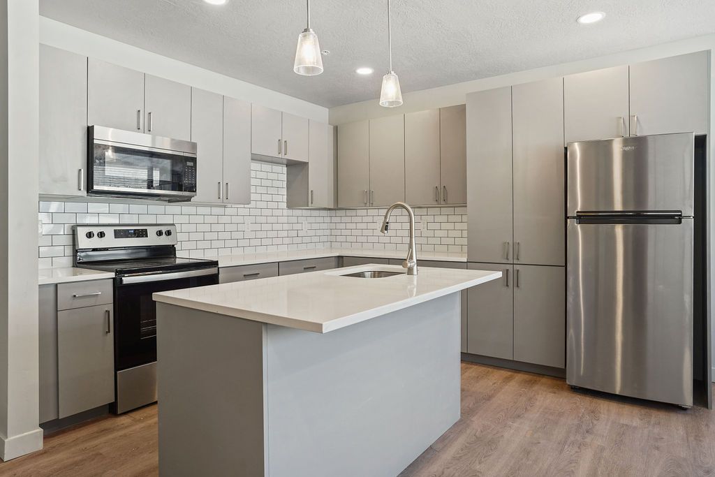 A kitchen with stainless steel appliances and a large island.